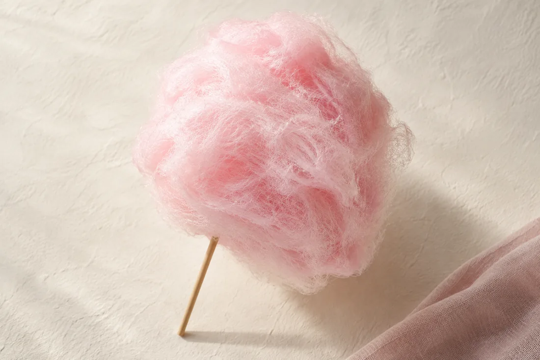 Un nuage de barbe à papa rose sur son bâton